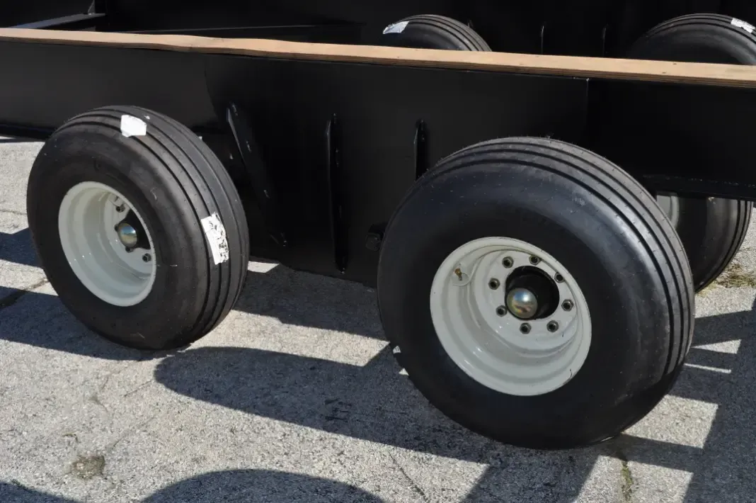 A black trailer with white wheels and tires