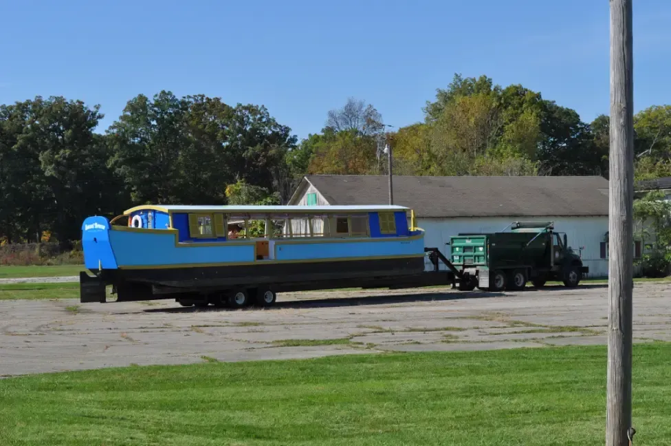 A boat is being towed by a truck in a parking lot