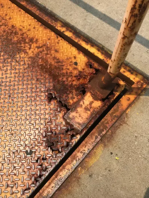 A rusty metal staircase with a broken railing