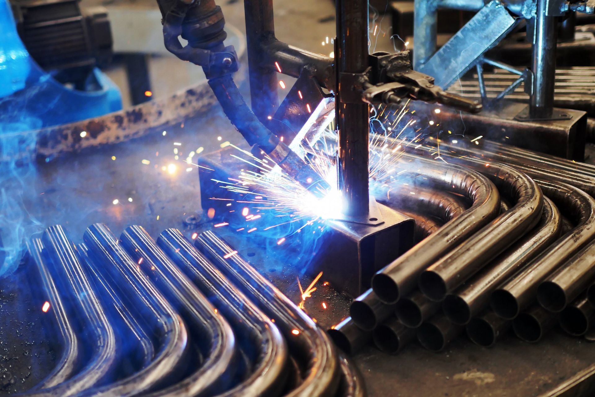 A robot is welding metal pipes in a factory.