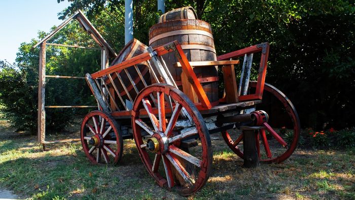 A wooden wagon with a wooden barrel in it