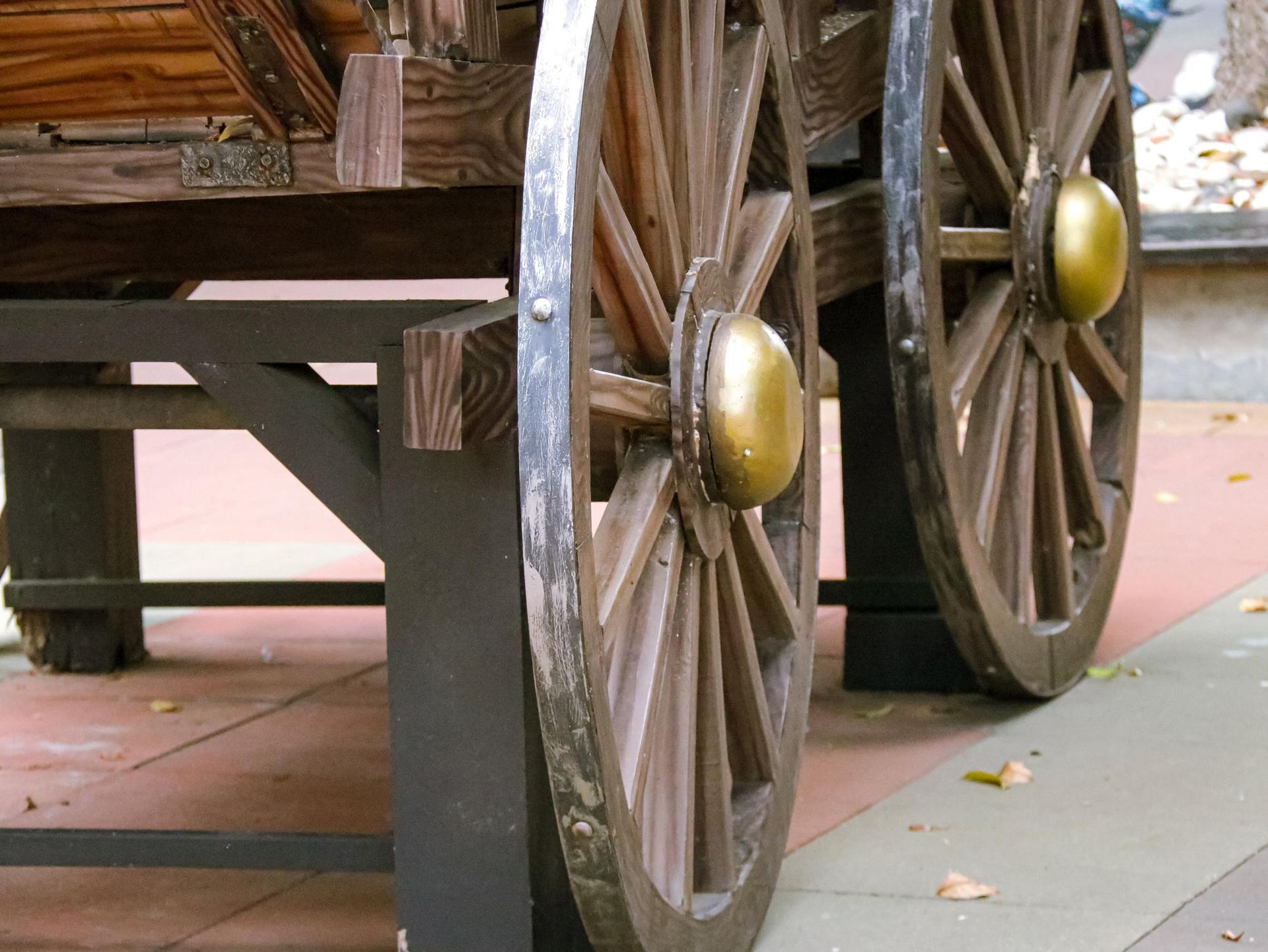 A pair of wooden wagon wheels with gold handles