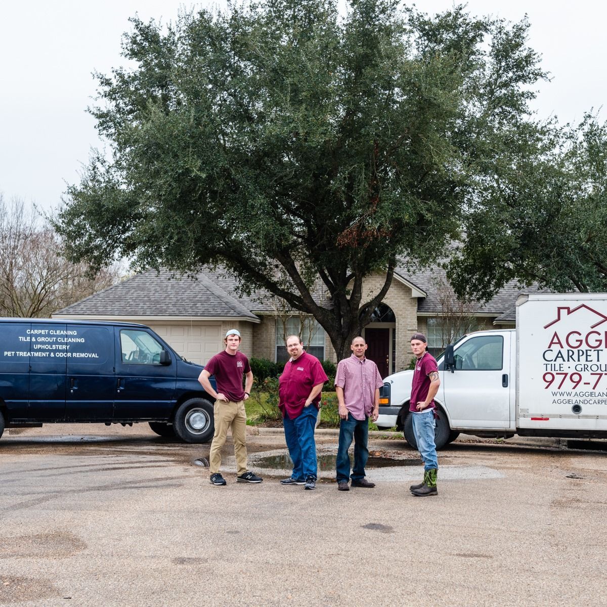 a group of men are standing in a parking lot in front of a house .
