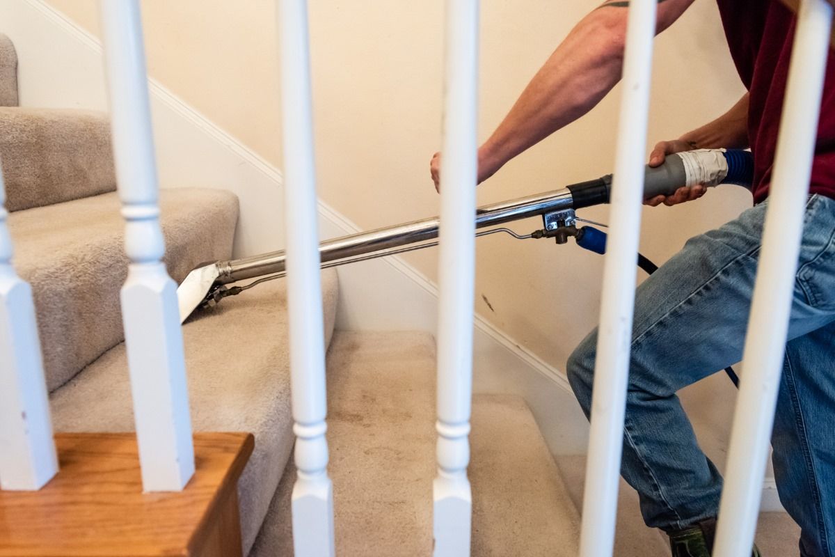 a man is cleaning a staircase with a vacuum cleaner .