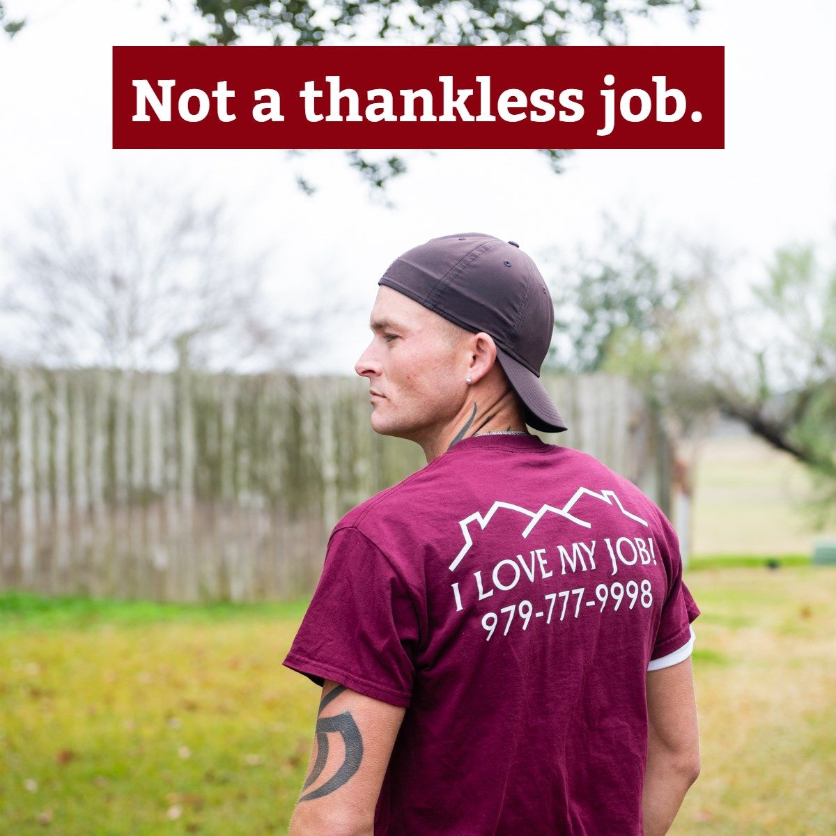 a man wearing a maroon shirt that says i love my job