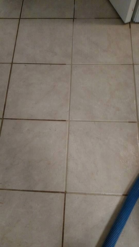 a close up of a tiled floor with a blue mop .