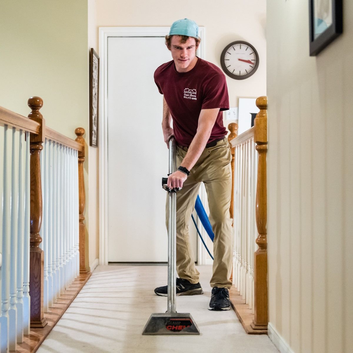 a man in a maroon shirt is sweeping the floor
