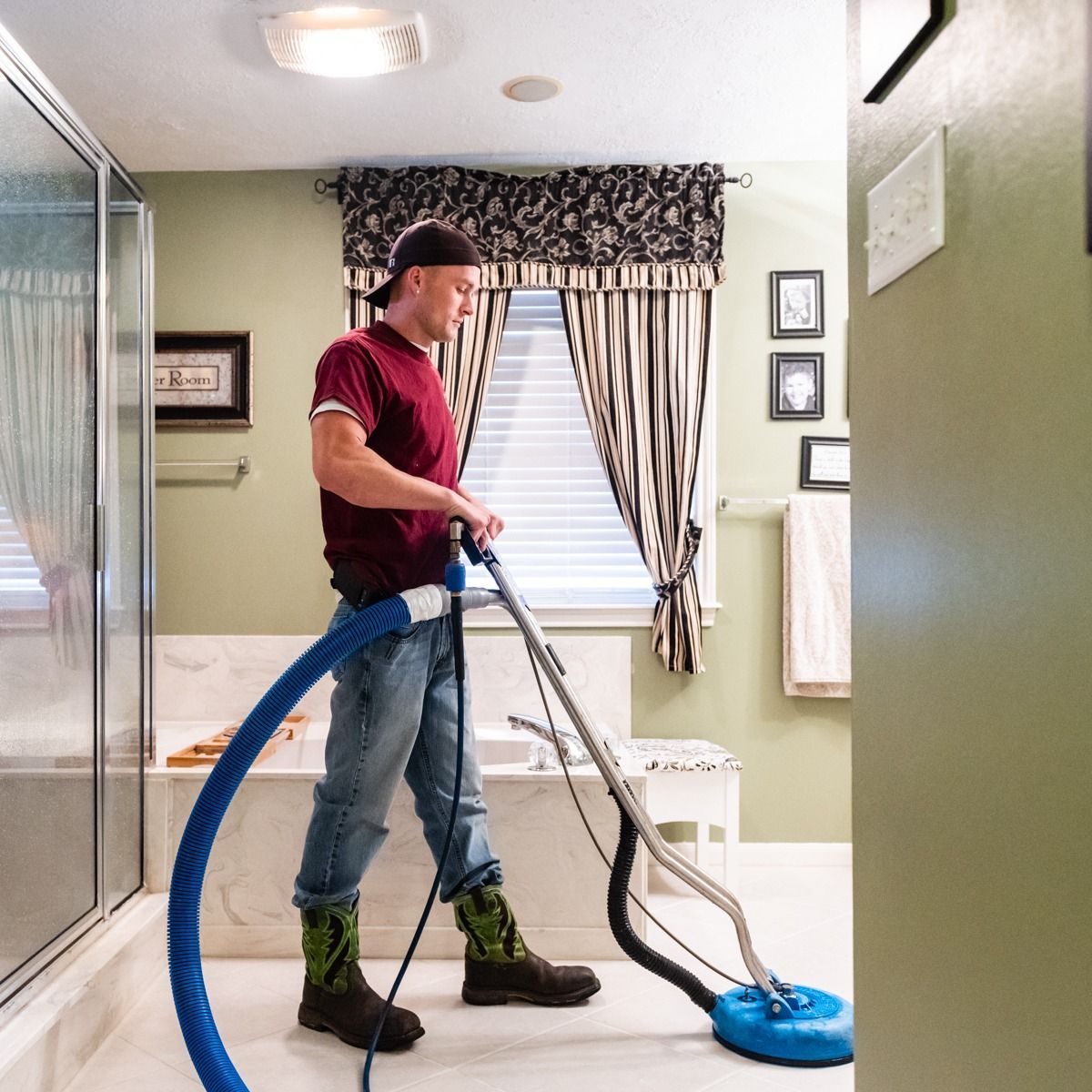 a man is using a vacuum cleaner in a bathroom