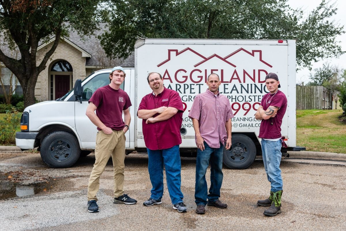 a group of men are standing in front of a carpet cleaning truck .