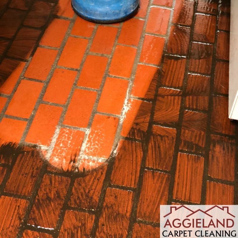 a brick floor is being cleaned by aggieland carpet cleaning