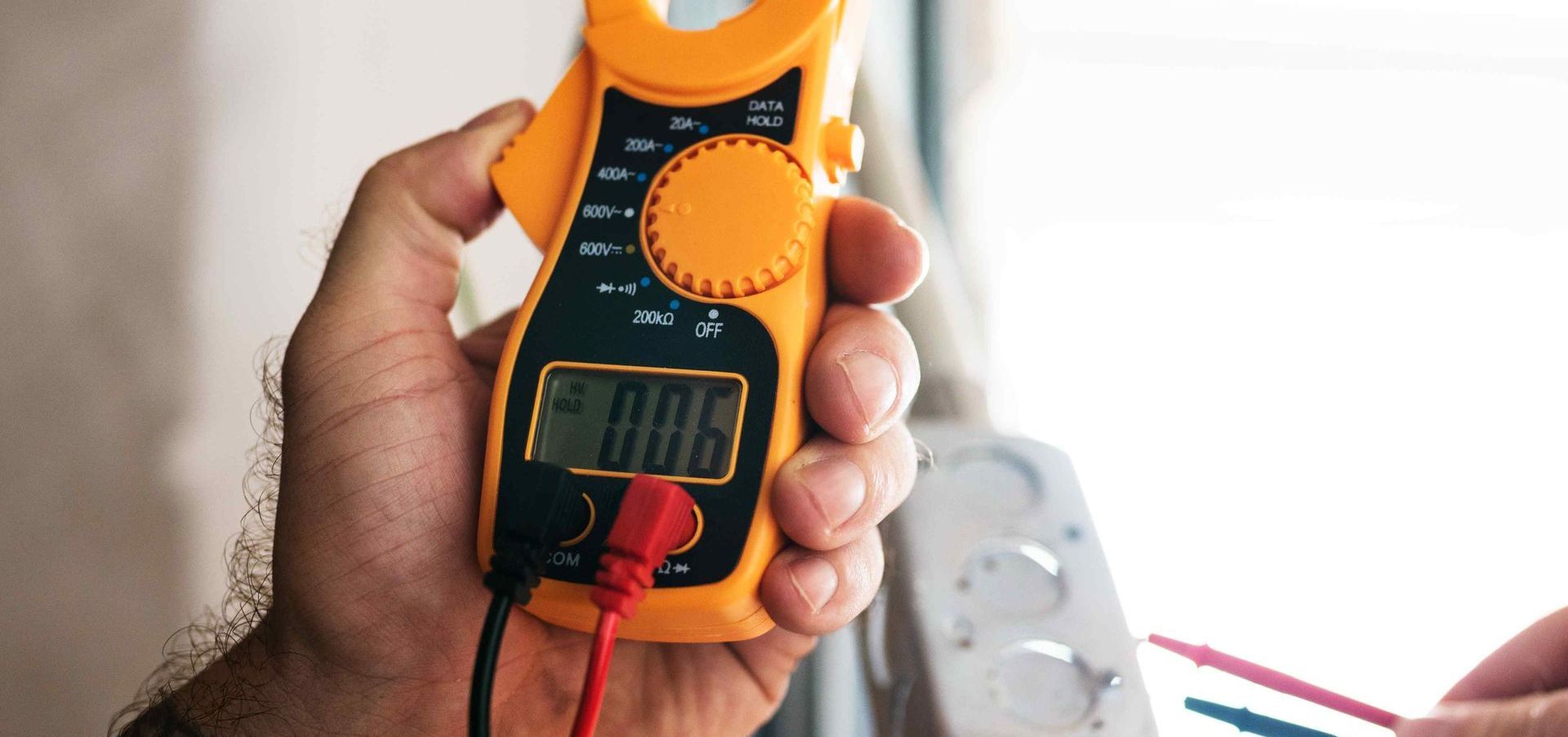 Affordable Electrician Using Volt-Meter Checking Voltages