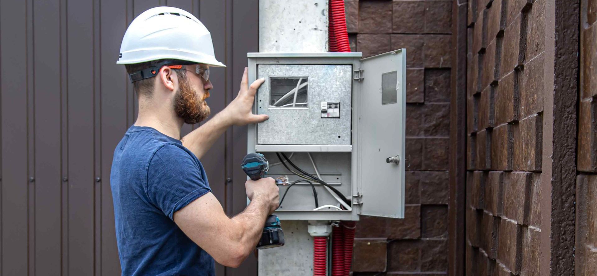 Electrician Examines Old Outdoor Electrical Box For Local Business