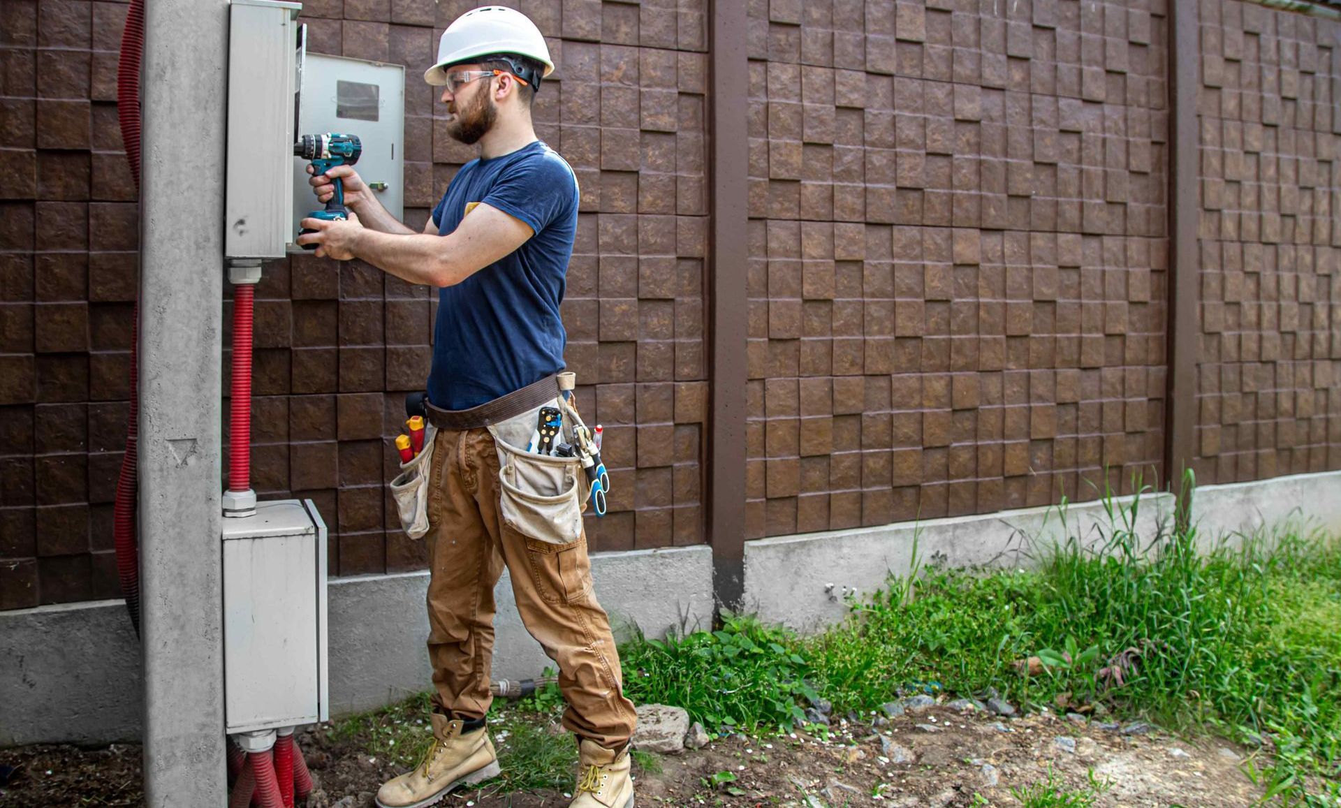 Electrician Examining Outdoor Electrical Conduit Box