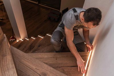 Electrician Installing Affordable LED Lighting On Stairs of House