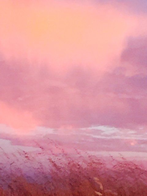 A painting of a field with a pink sky in the background.
