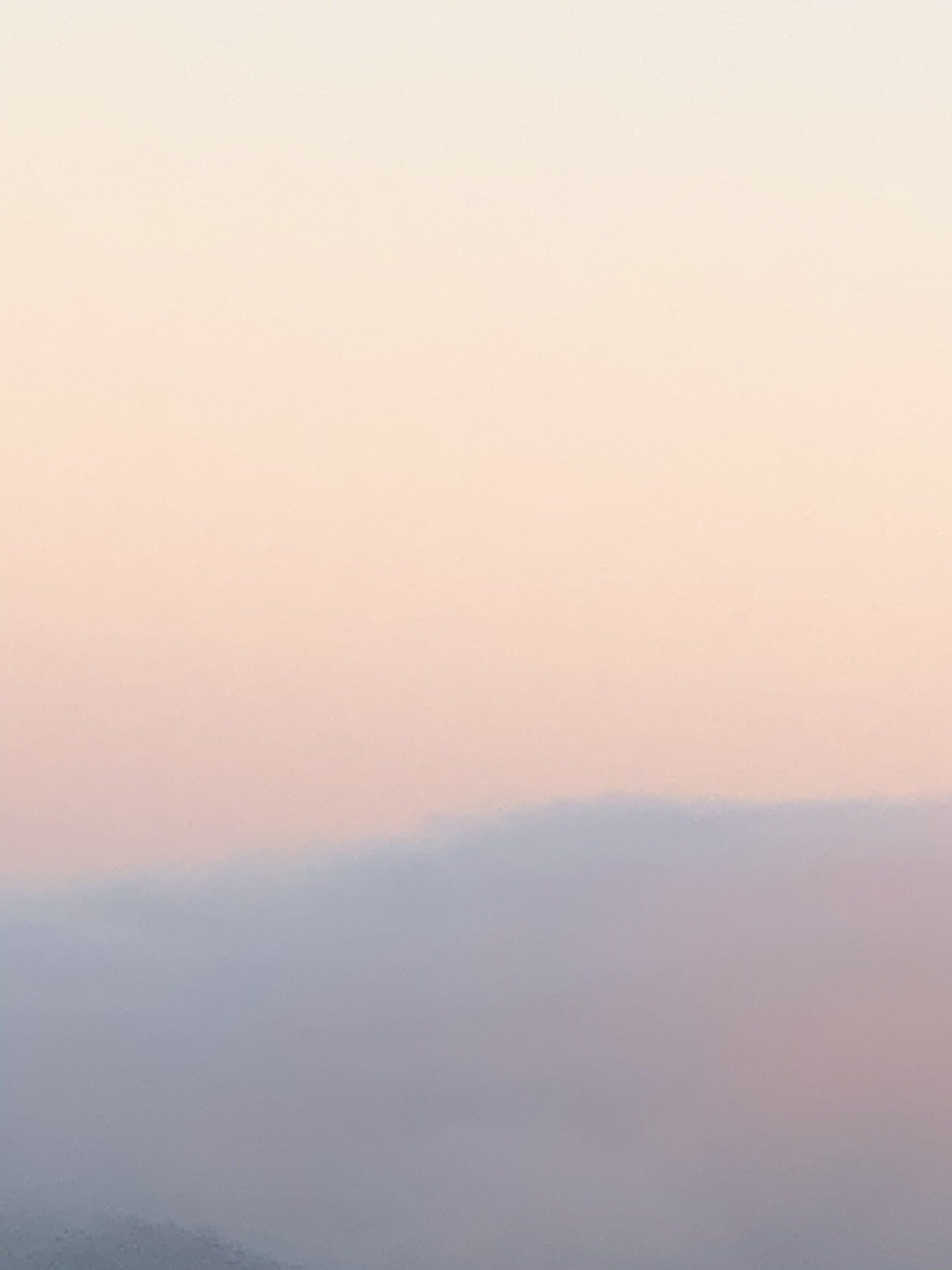 A sunset over a body of water with mountains in the background