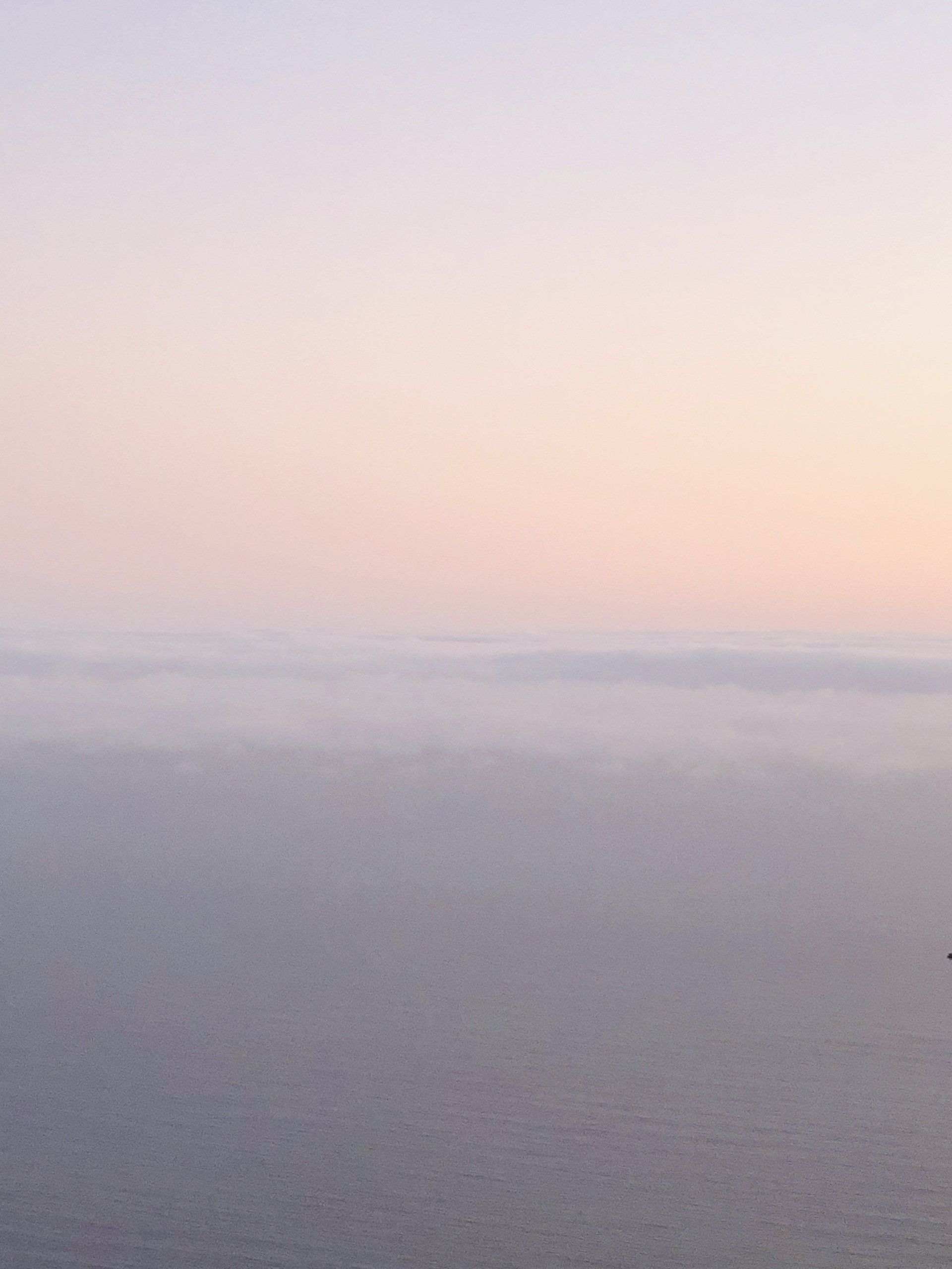 A view of the ocean at sunset with a purple sky in the background.