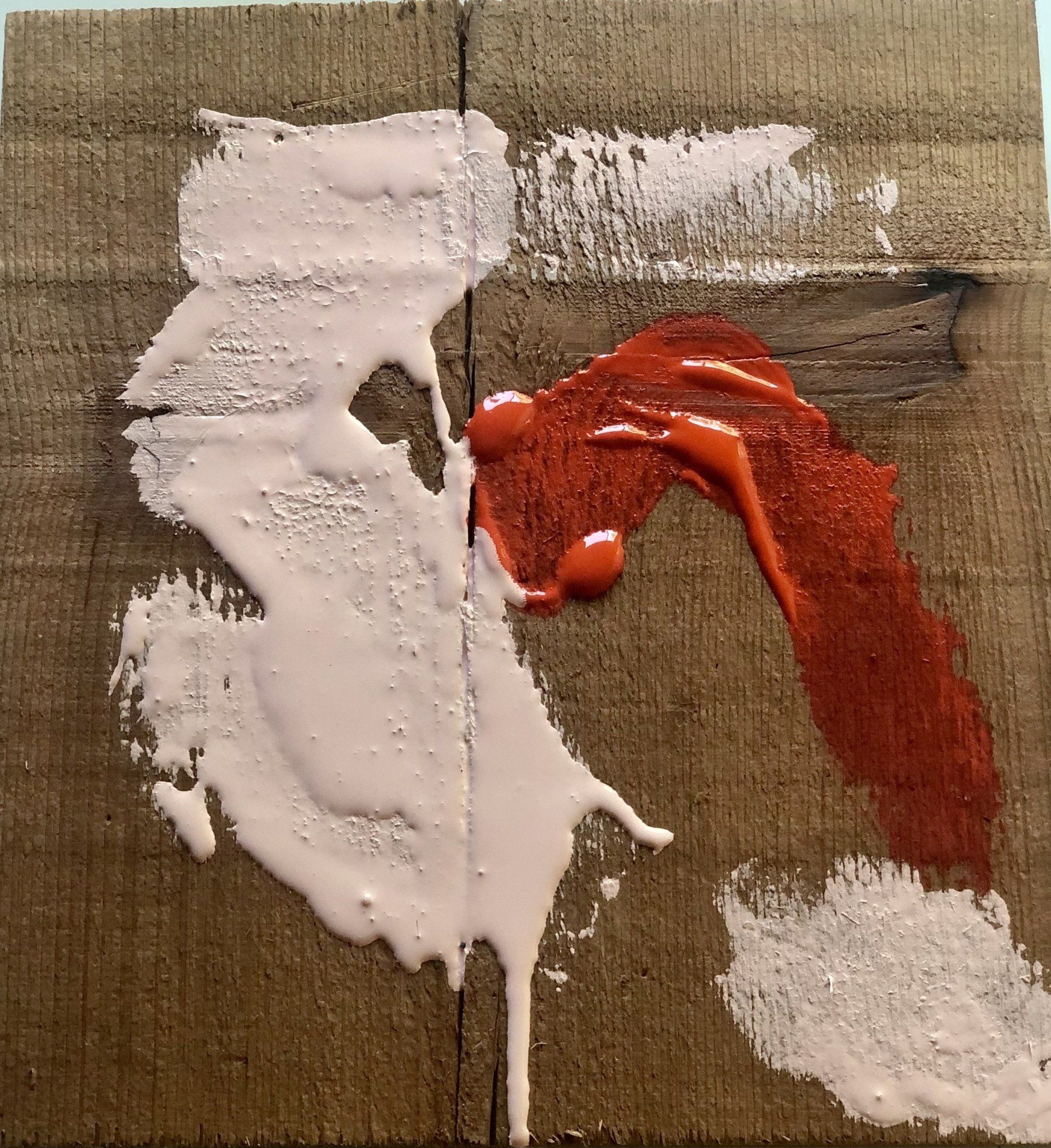 A piece of wood with white and red paint on it