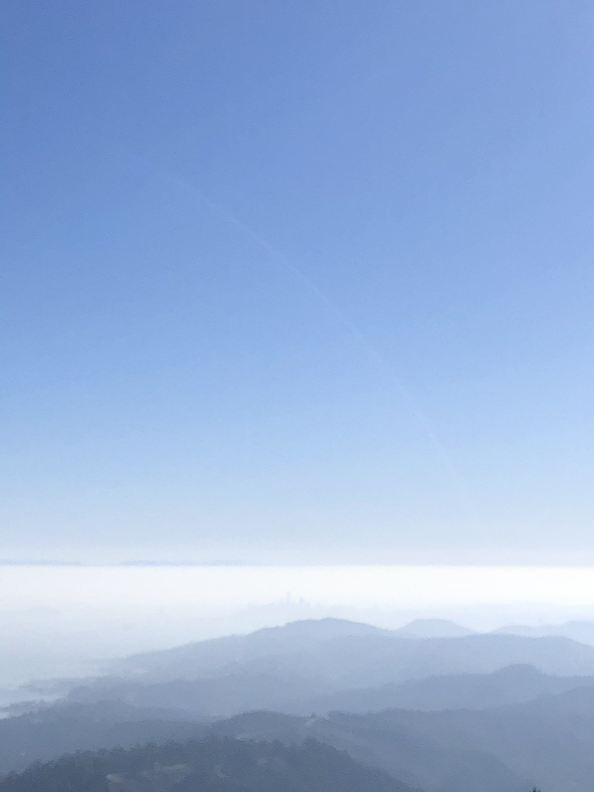 A view of a mountain range with a blue sky in the background.