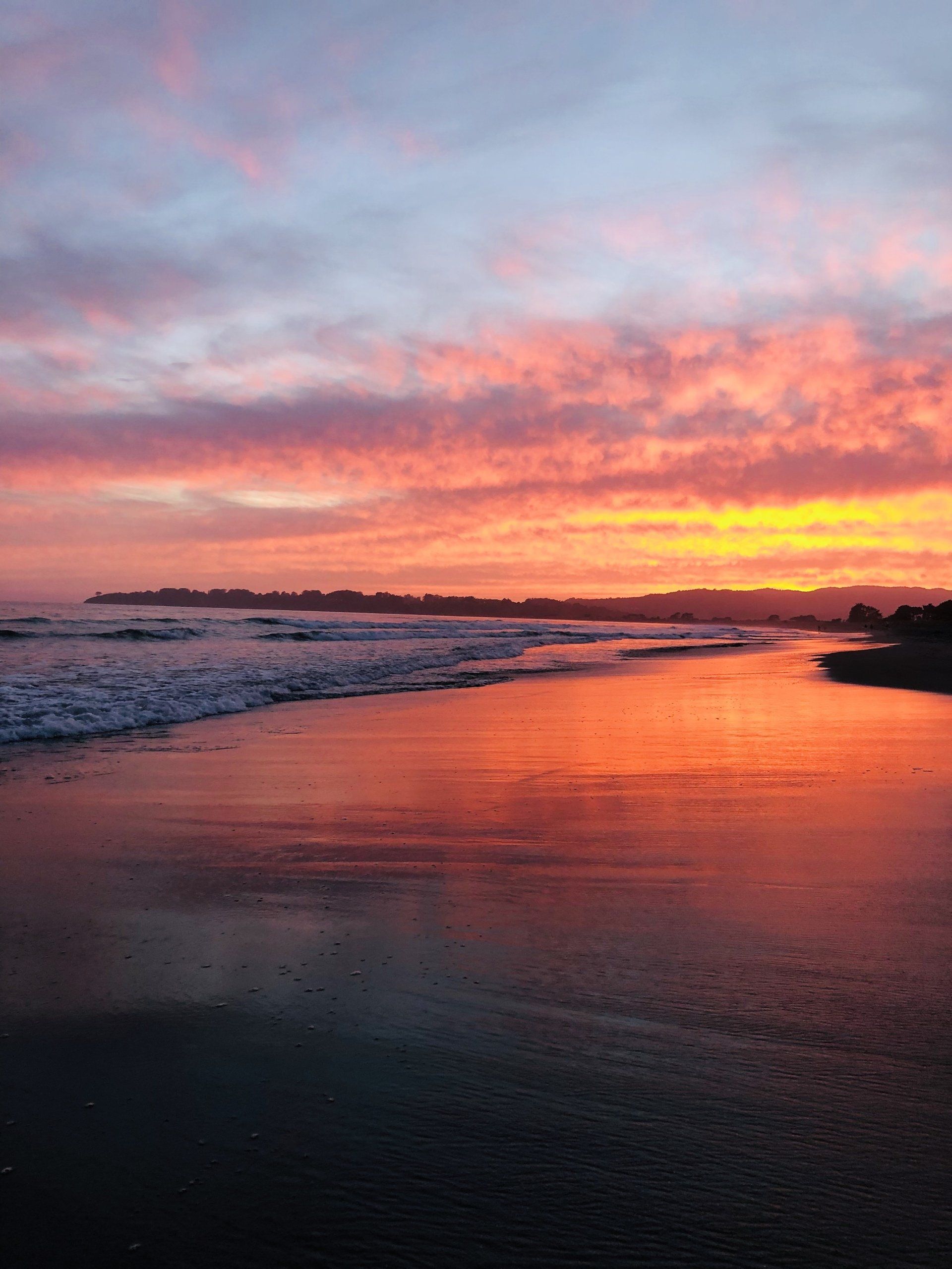 A beach with a sunset in the background