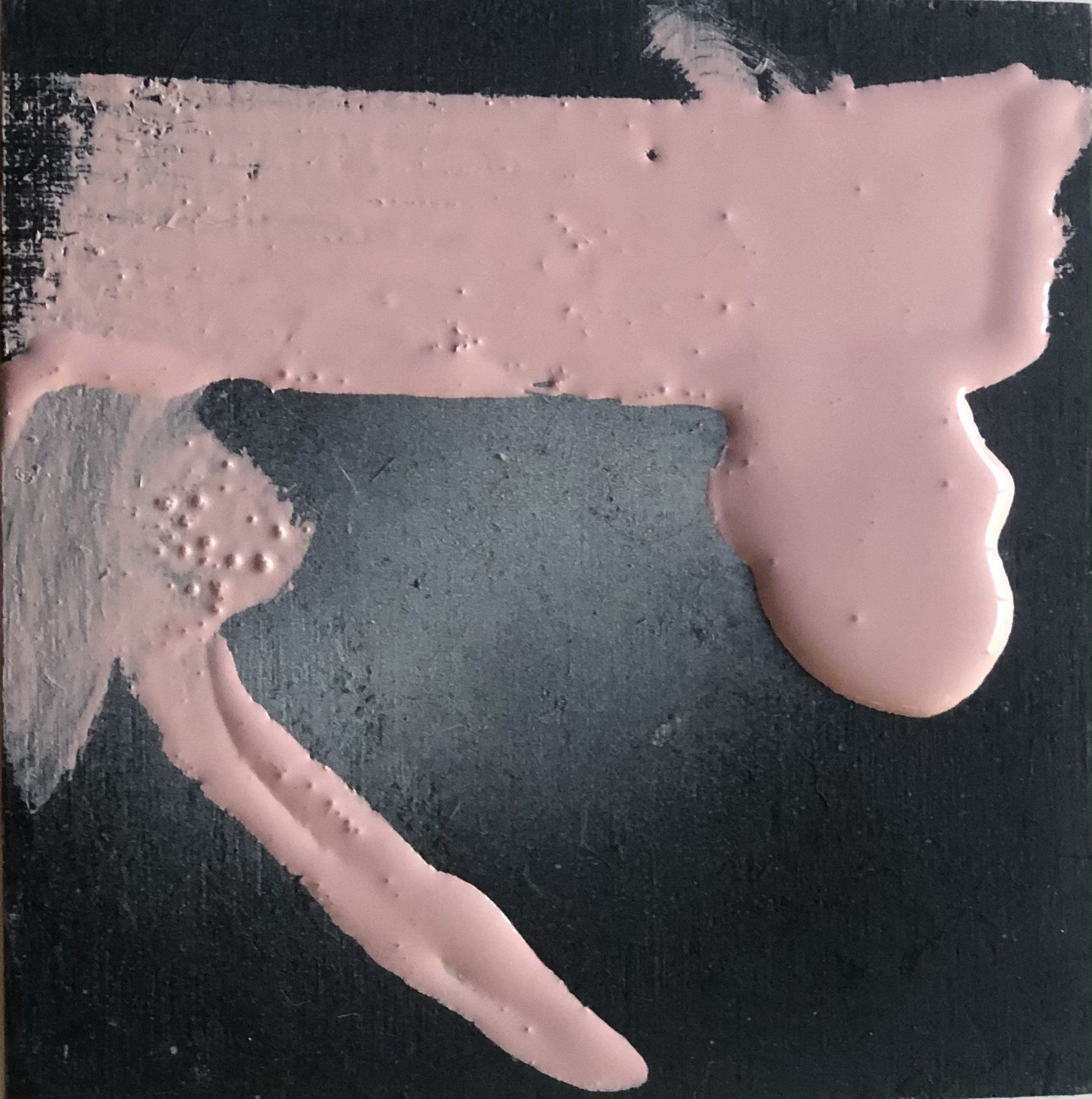 A pink paint brush stroke on a black surface