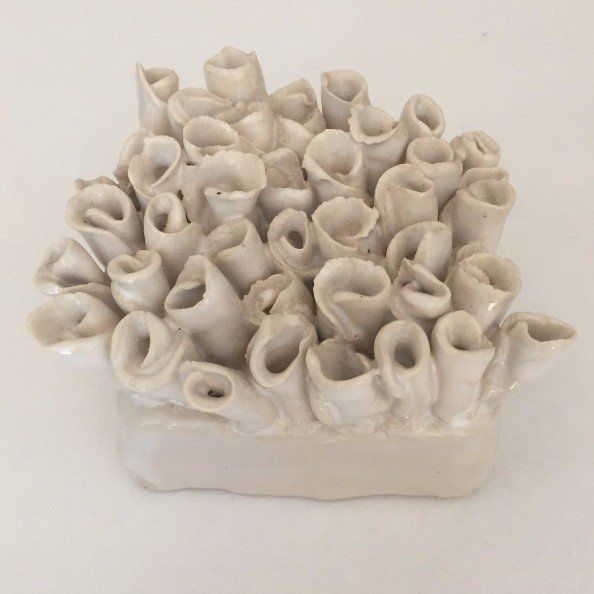 A white vase with a bunch of flowers on it