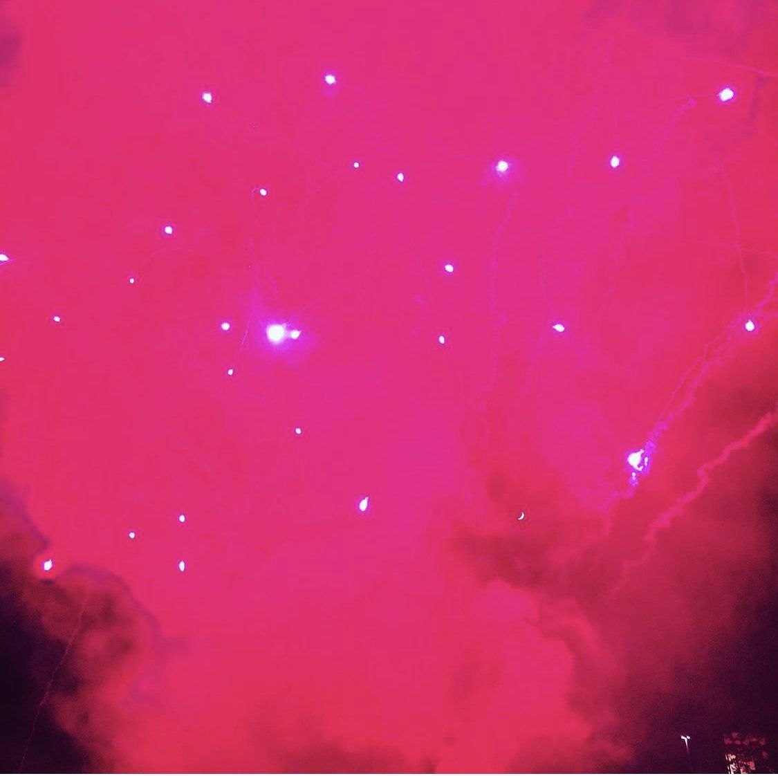 A pink fireworks display in the night sky