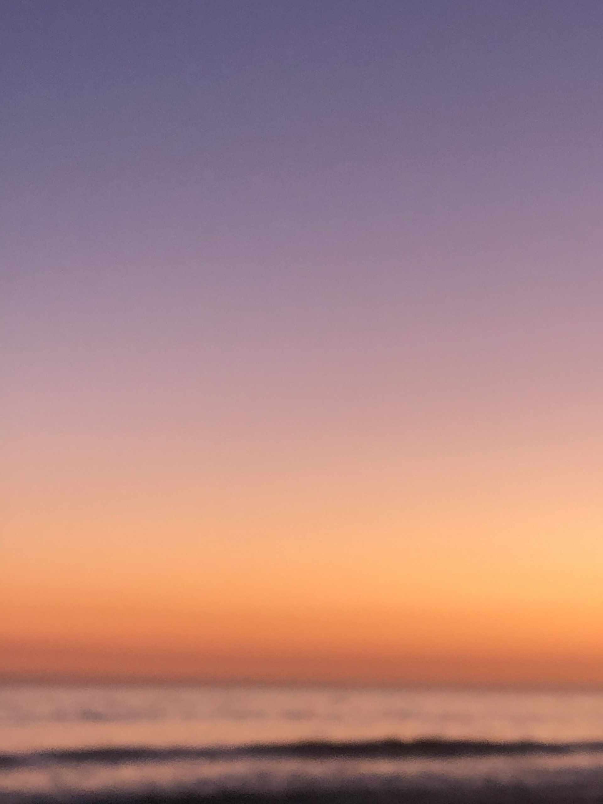 A blurry picture of a sunset over the ocean.