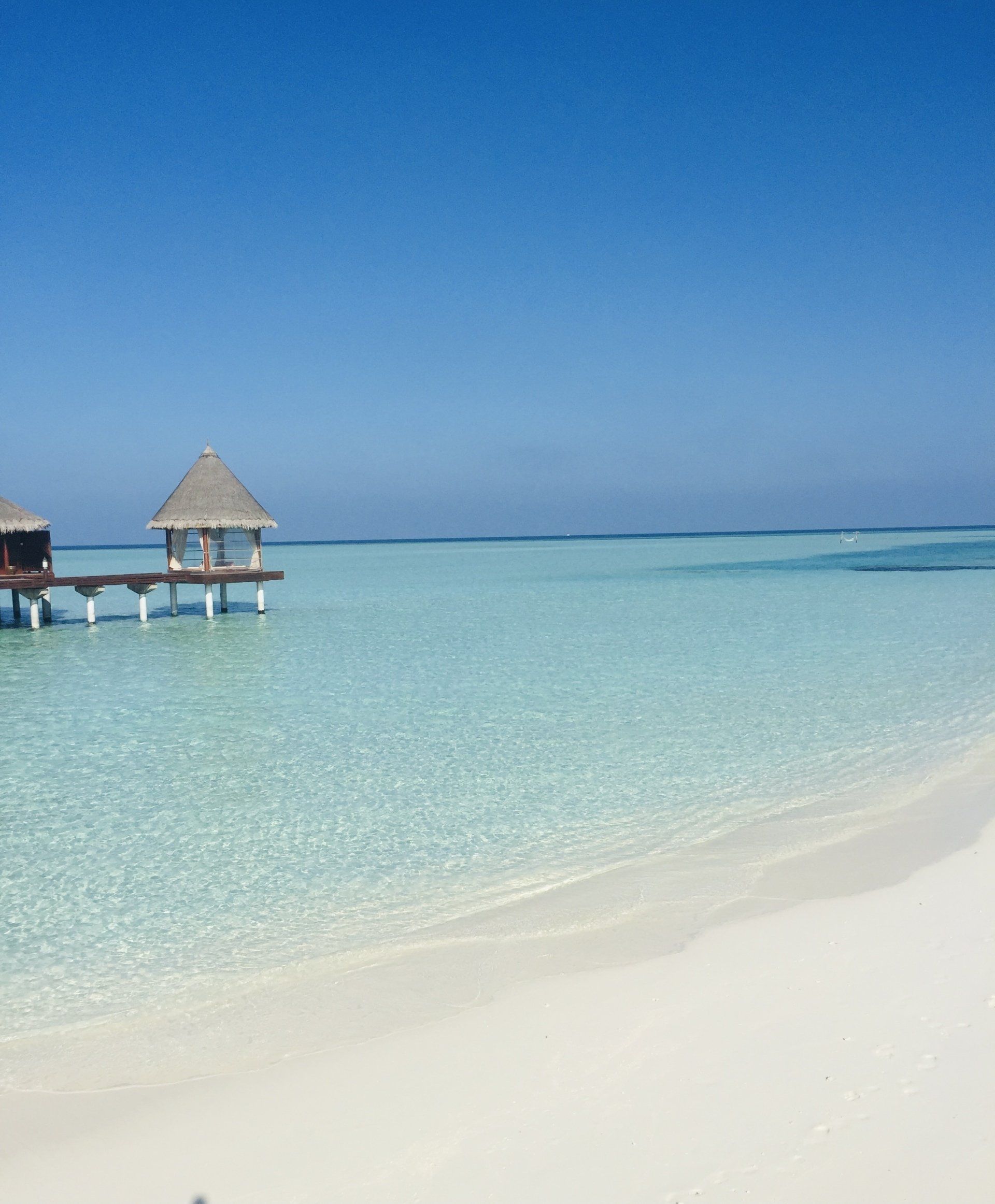 A small hut on a dock in the middle of the ocean