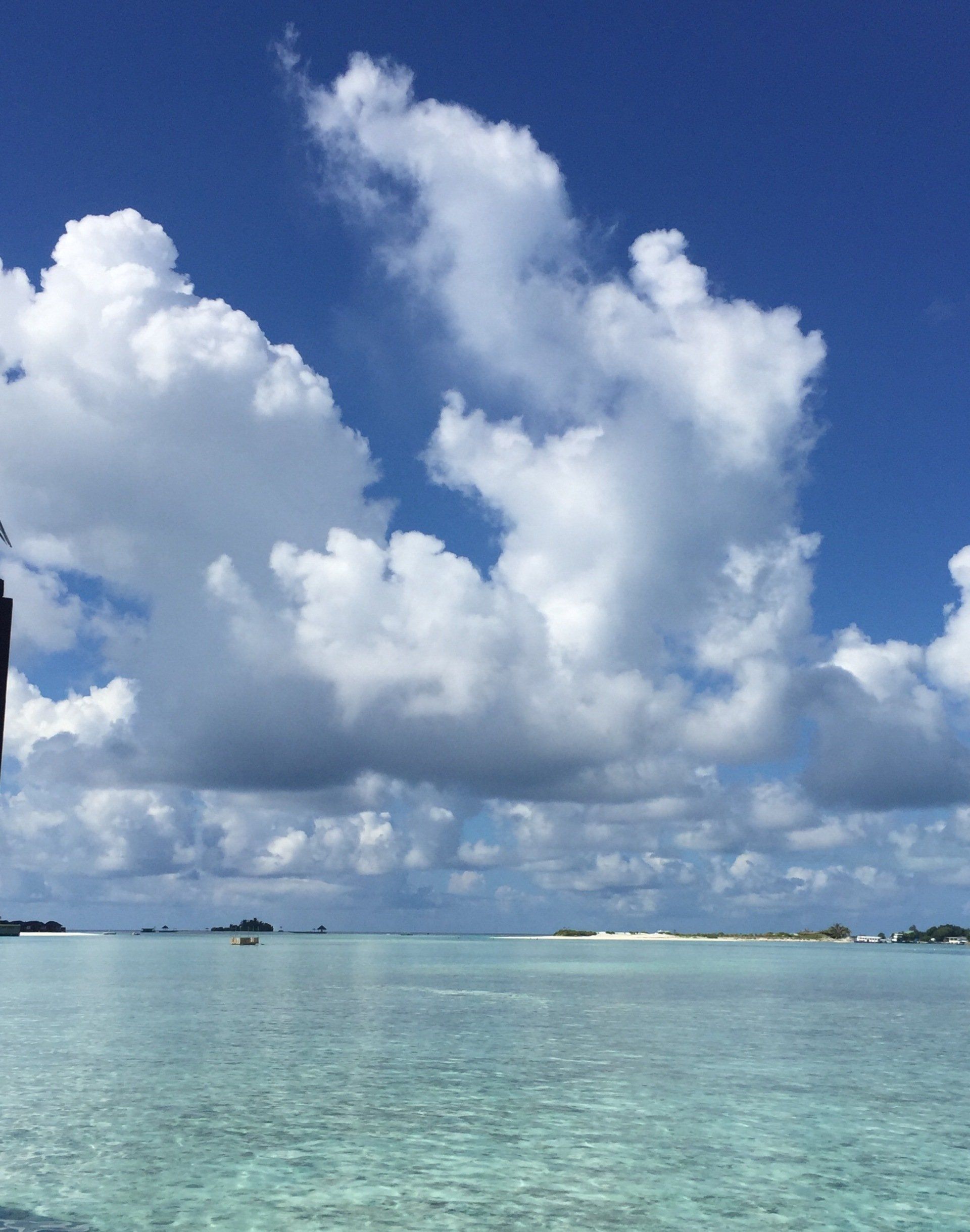 A blue sky with white clouds over a body of water