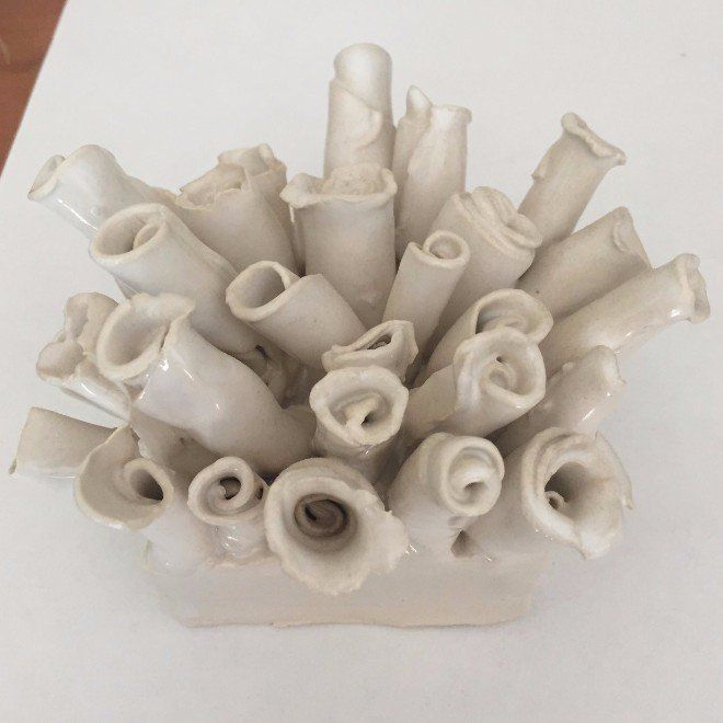 A bunch of white vases are sitting on a table