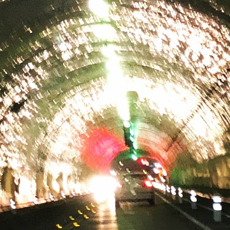 A car is driving through a tunnel at night