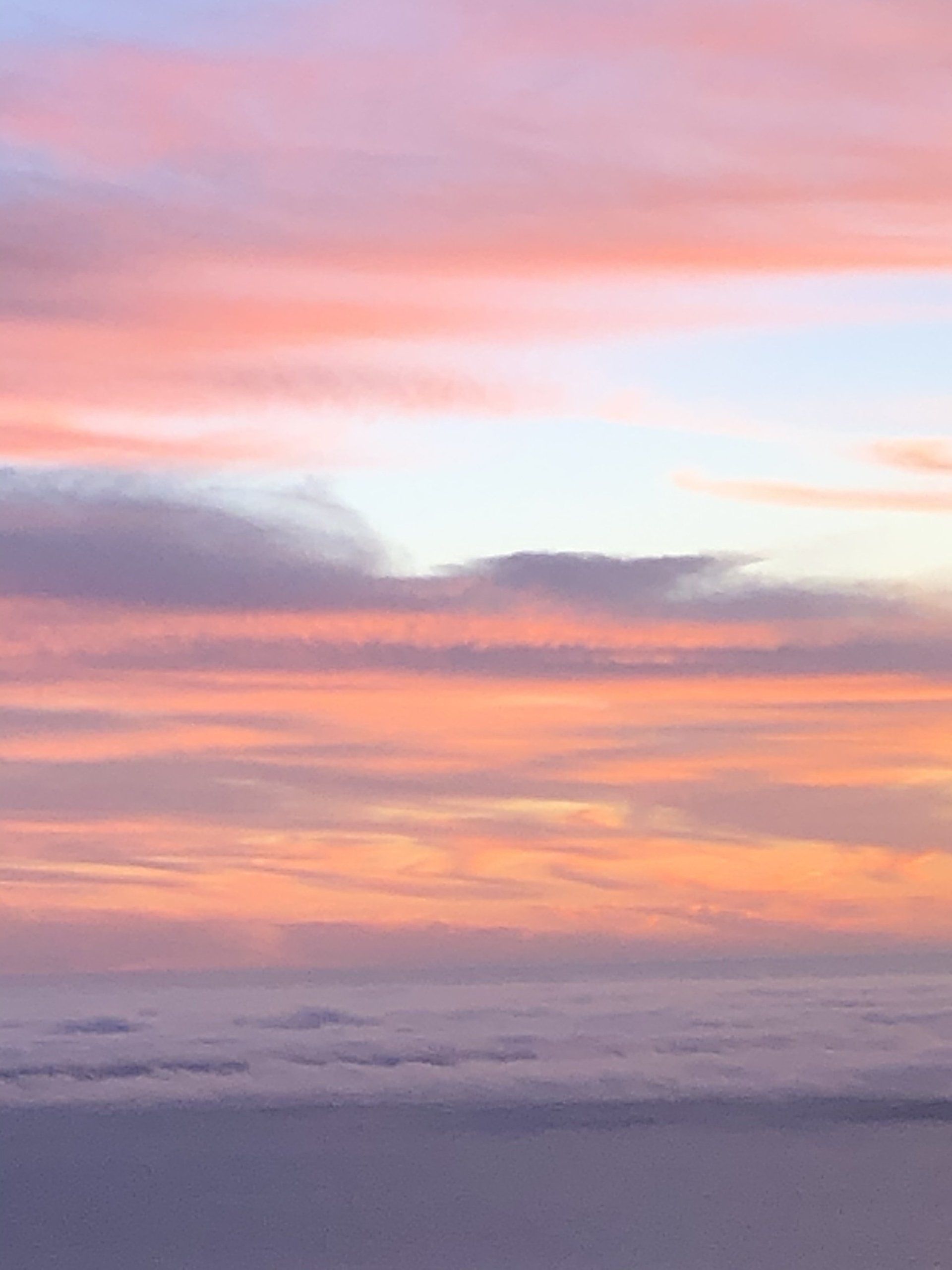 A sunset over a body of water with clouds in the sky