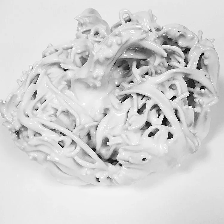 A close up of a white sculpture on a white surface