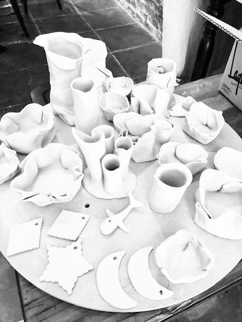A black and white photo of a table full of ceramics