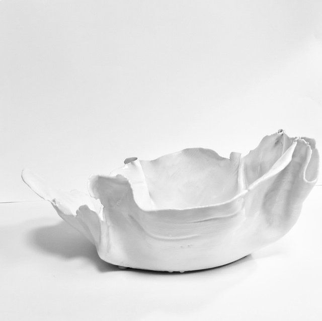 A white bowl is sitting on a white surface.