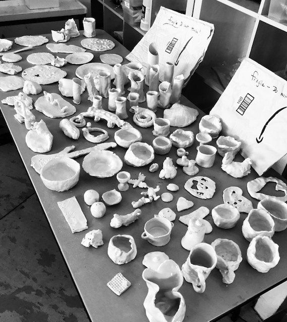 A black and white photo of a table full of ceramics