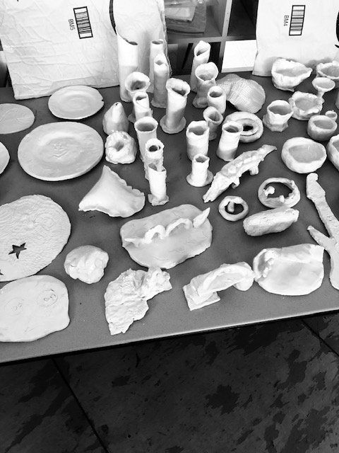 A black and white photo of a table full of ceramics