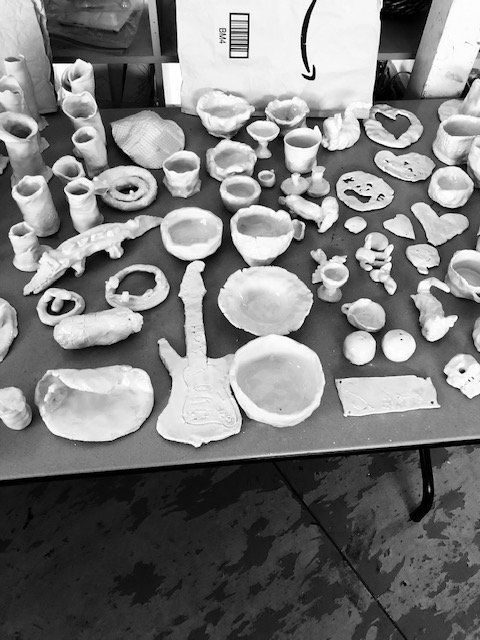 A black and white photo of a table full of ceramics