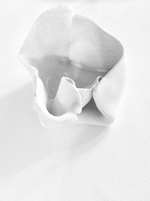 A close up of a white bowl on a white surface.