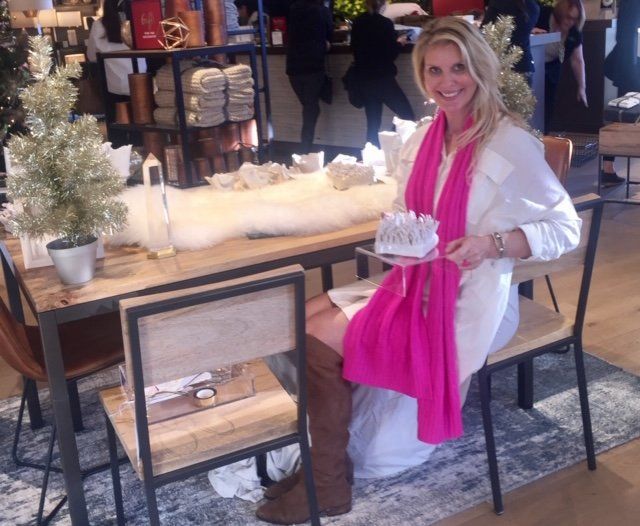 A woman wearing a pink scarf is sitting at a table