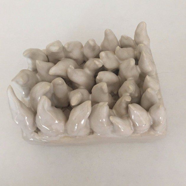 A white ceramic soap dish with a lot of birds on it.