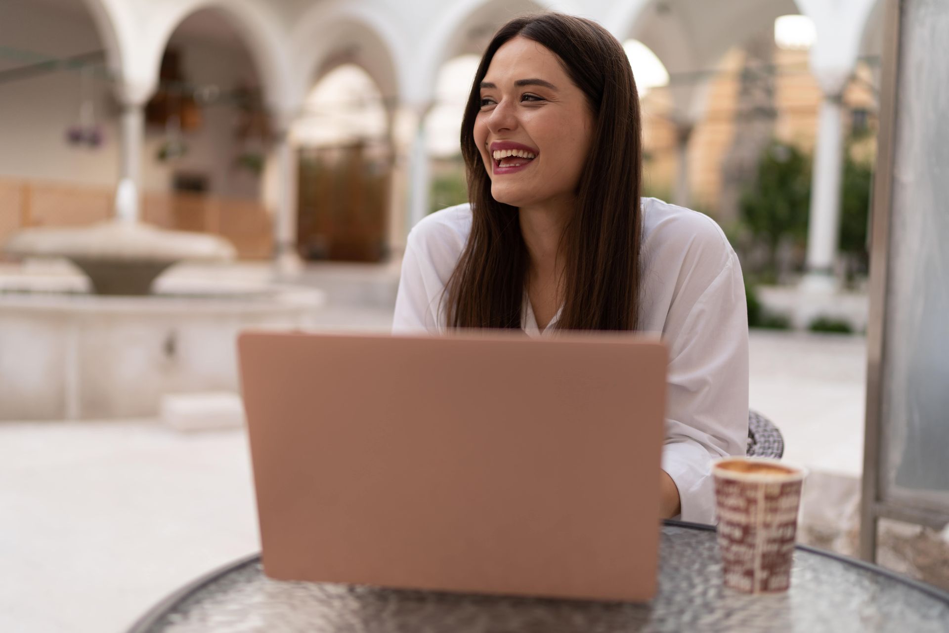 A woman and two little girls wearing crowns are sitting on a couch.