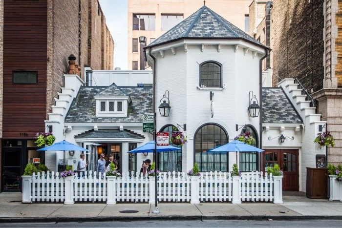 A white building with blue umbrellas in front of it