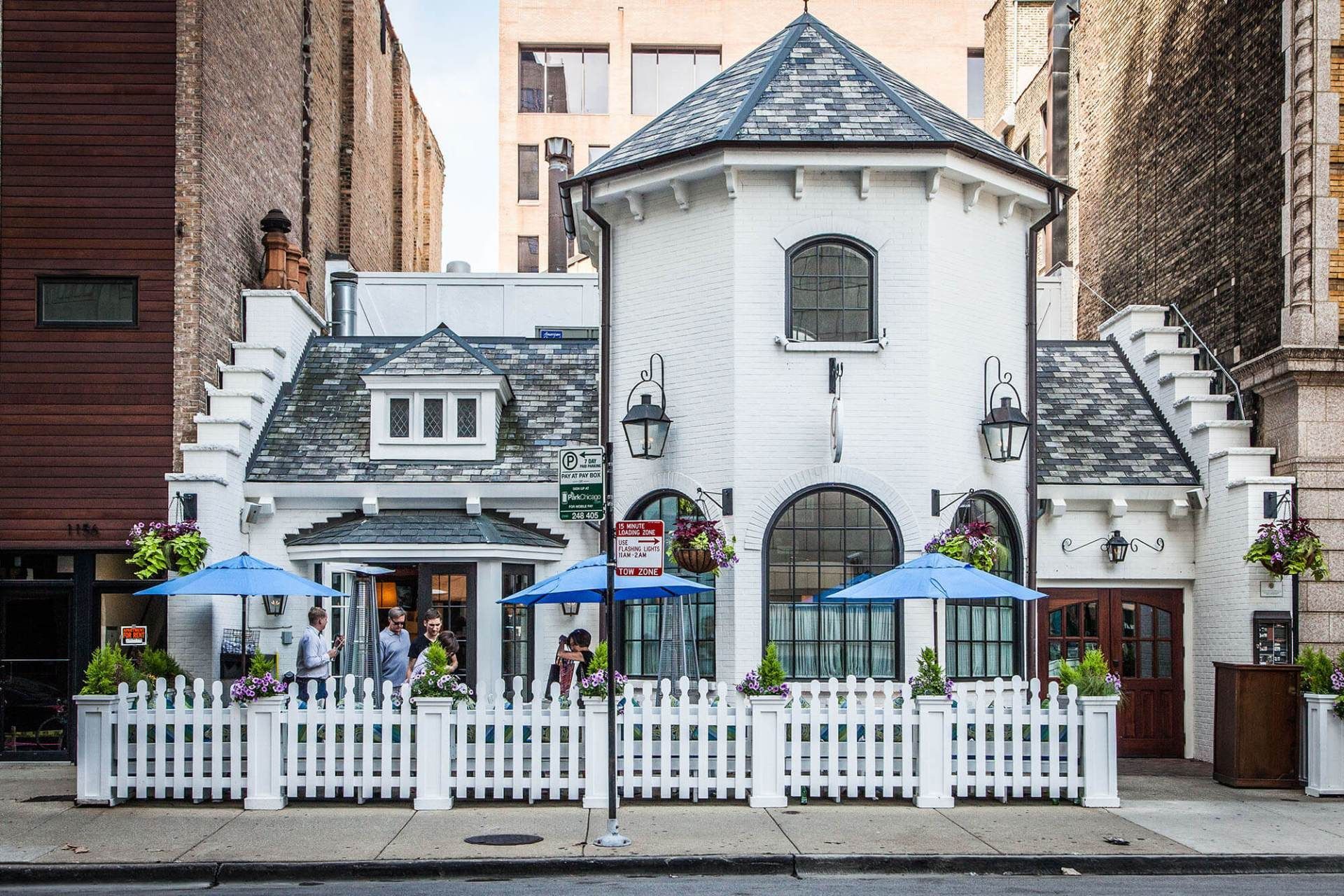 A white building with blue umbrellas in front of it