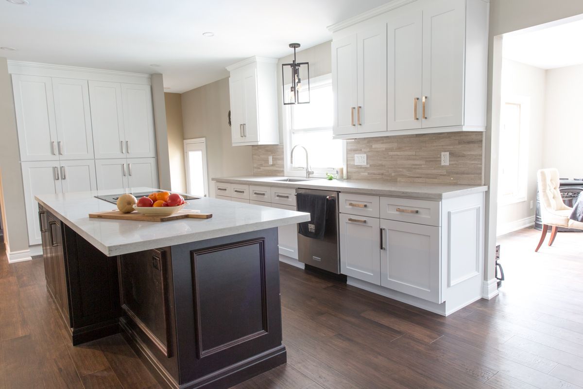 A kitchen with white cabinets and a large island in the middle.