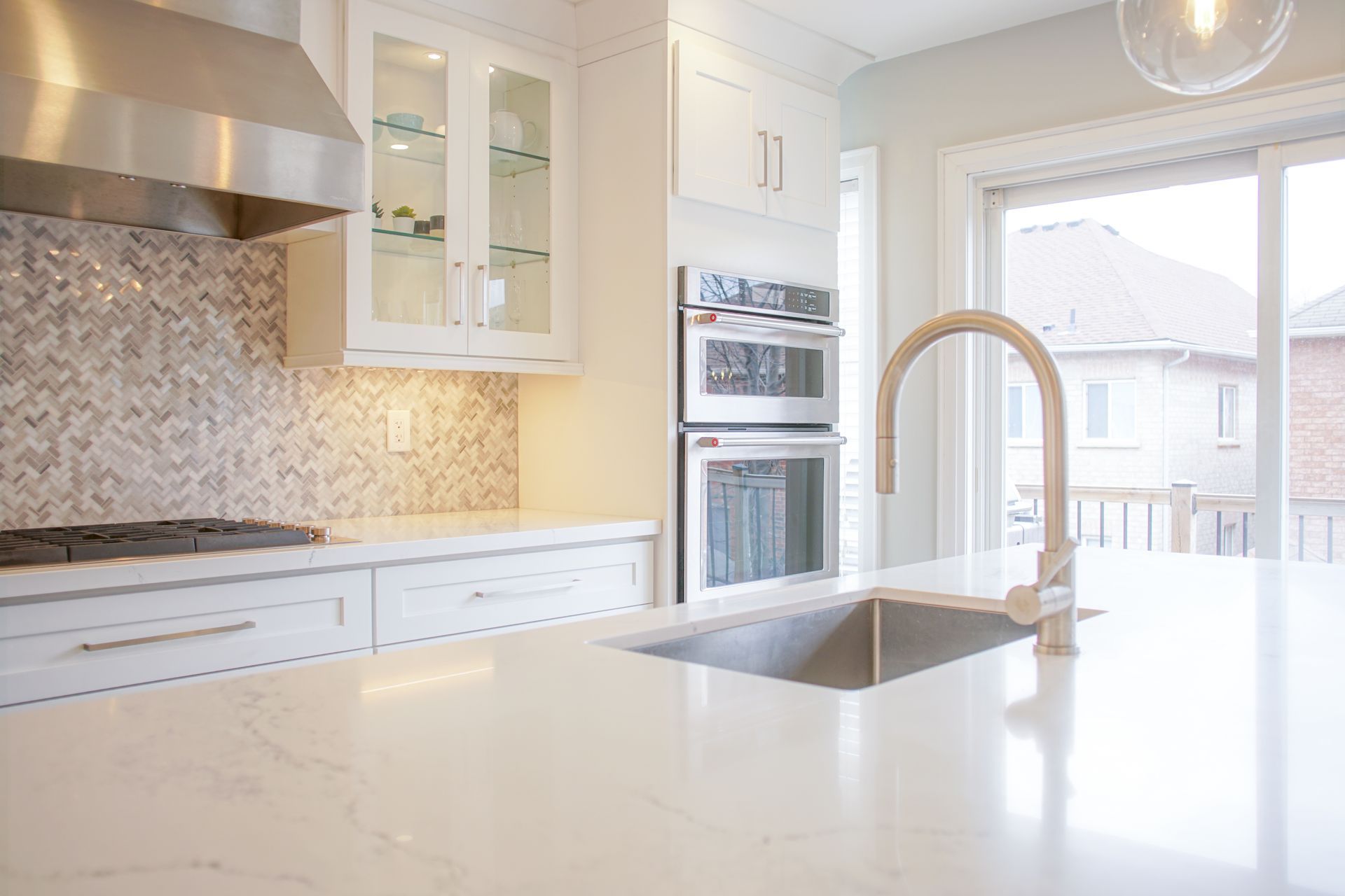 A kitchen with white cabinets , stainless steel appliances , a sink and a stove.