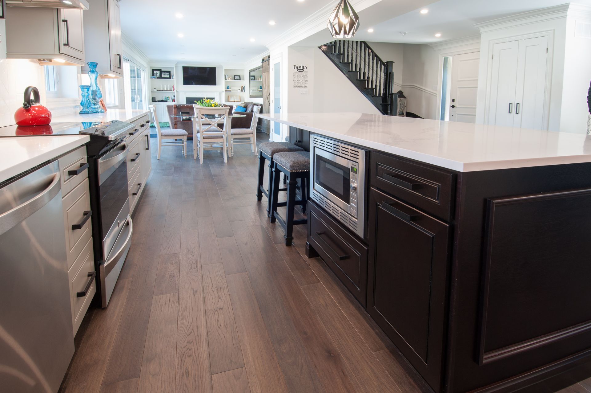 A kitchen with black cabinets and stainless steel appliances and a large island.