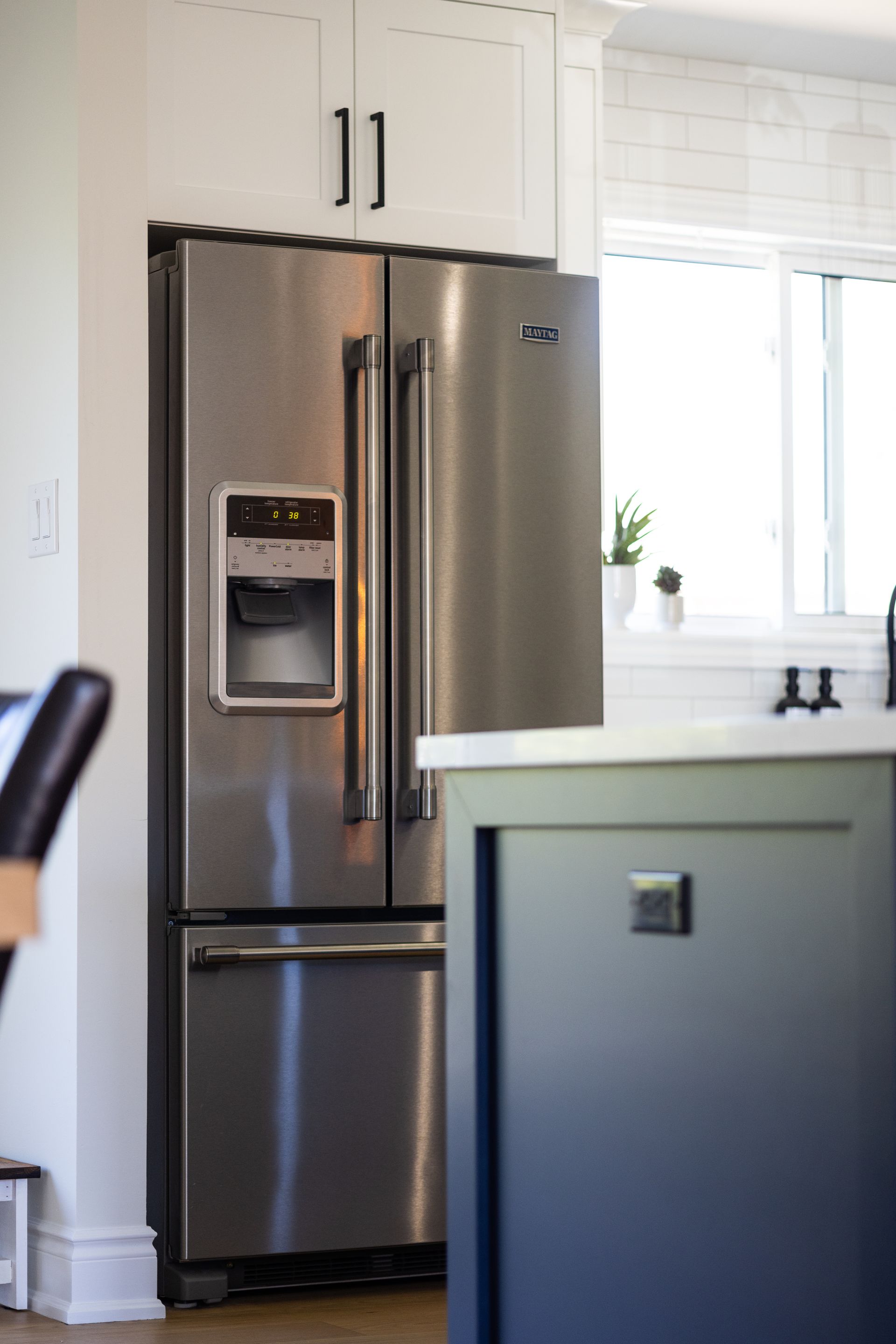 A kitchen with stainless steel appliances and white cabinets.