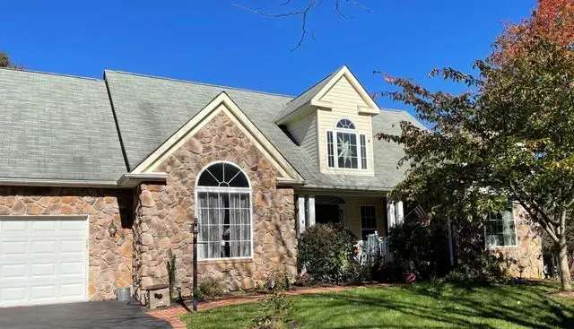 A large brick house with a gray roof and a white garage door.